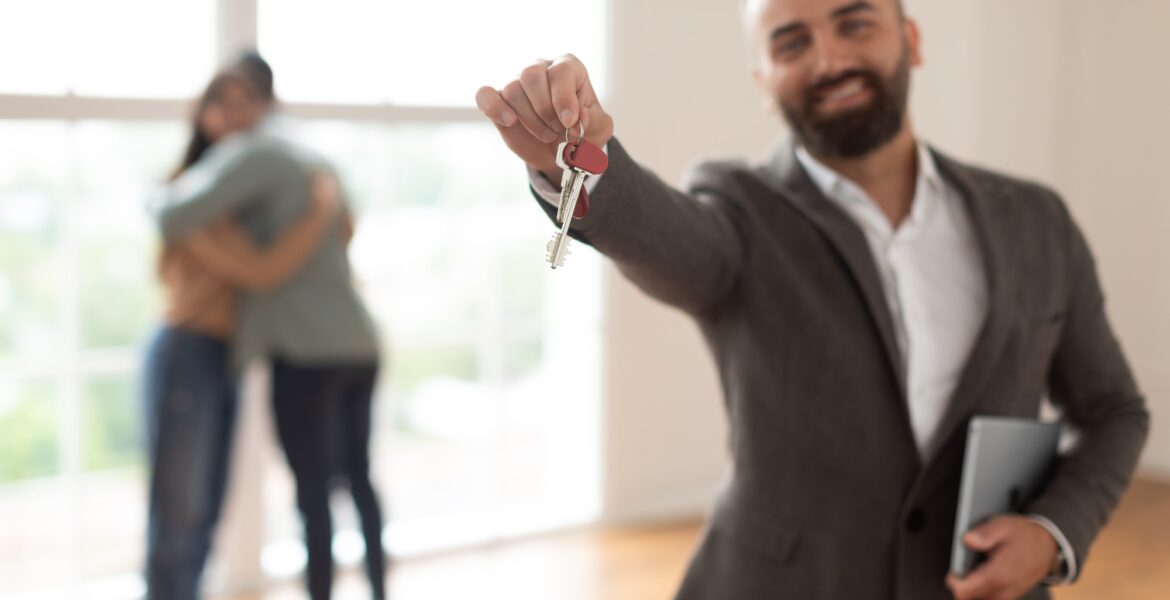 Smiling Real Estate Agent Holding And Showing Key